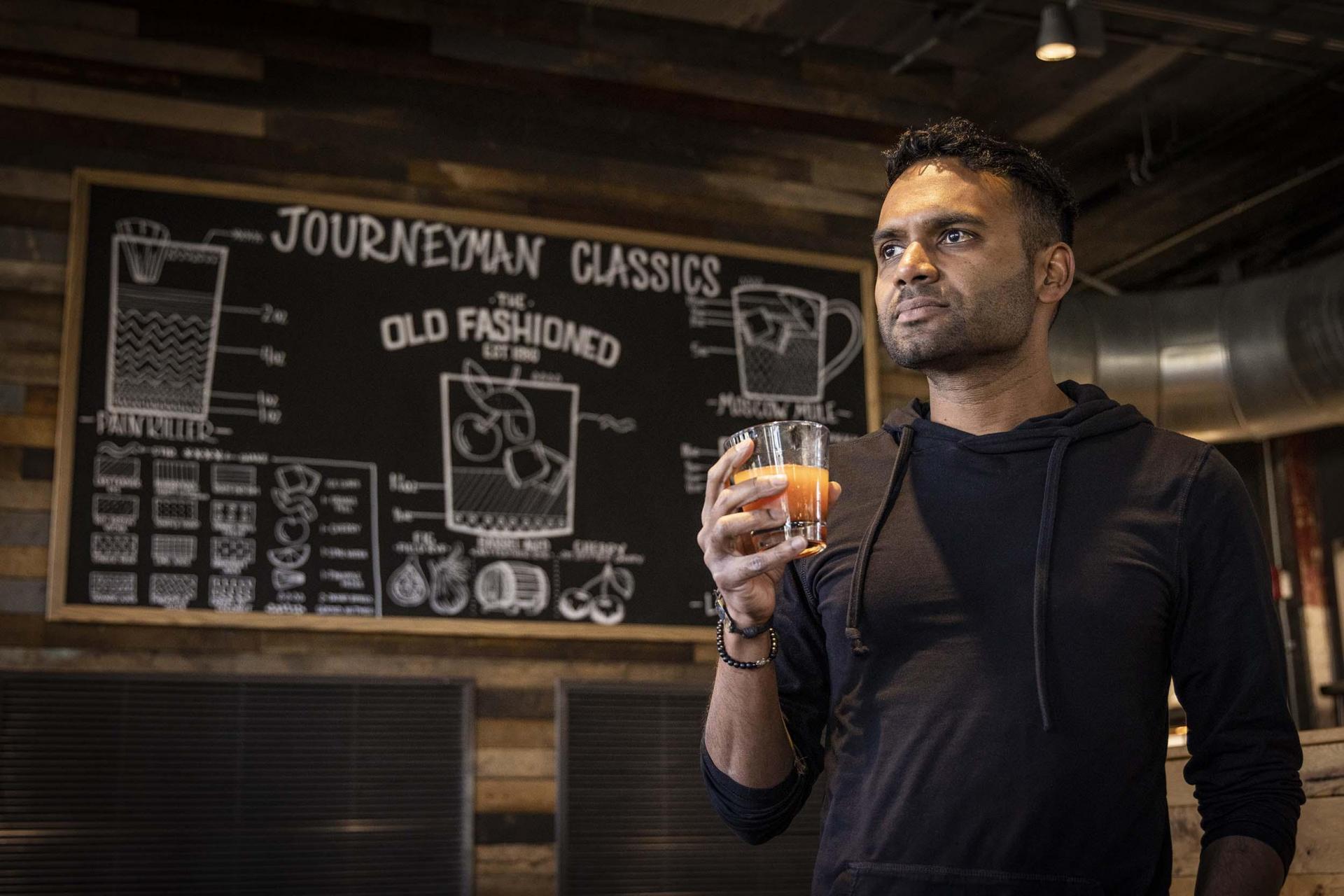 A person with a cocktail at Journeyman Distillery