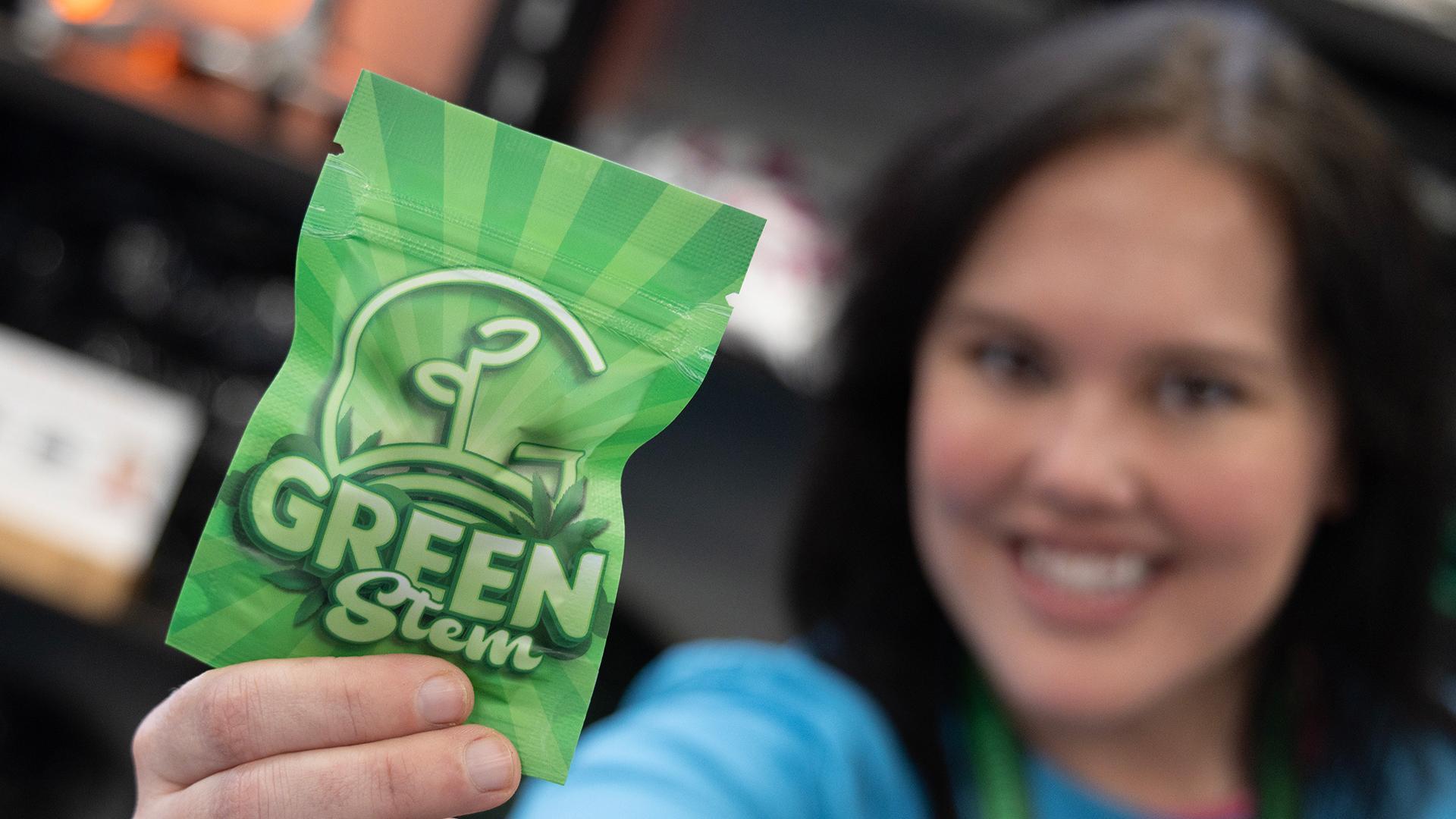 A woman holding a bag of Green Stem product